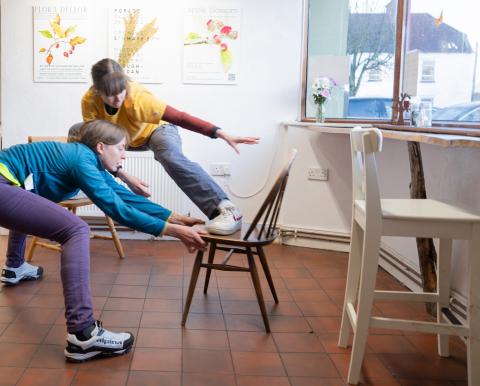 Girls dancing one with a foot on the chair