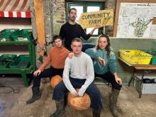 4 young people sitting on pumpkins